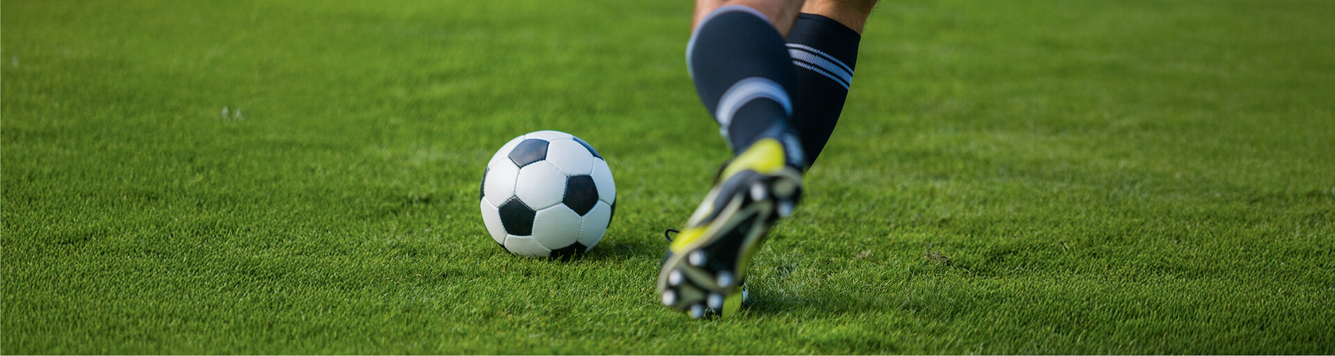 Fußball am Feld mit Fußballschuh und Wade des Spielers © Freepik