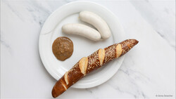 Weißwurst auf Teller mit Senf und Laugenstangerl | © Anna Stoecher