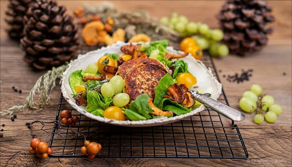 Kartoffel-Topfen-Laibchen auf Salat mit Eierschwammerl und Weintrauben | © Carletto Photography