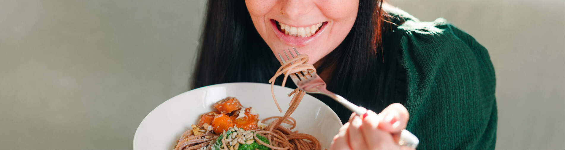 Frau isst Spaghetti und lächelt dabei | © Land schafft Leben