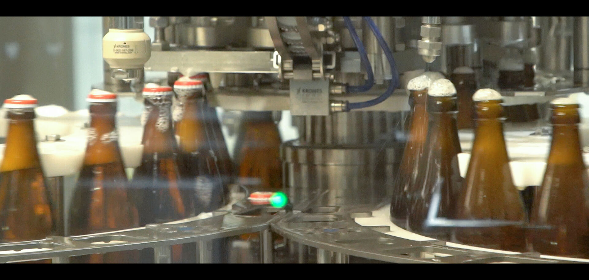 Bierflaschen während Füllung auf Fließband | © Land schafft Leben