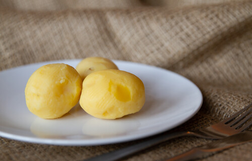 Drei geschälte Kartoffeln auf Teller | © Land schafft Leben
