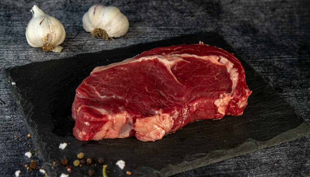 Rohes Rinder Steak Ribeye auf schwarzer Platte | © Land schafft Leben