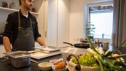 Koch steht in Küche vor Arbeitsfläche | © Land schafft Leben