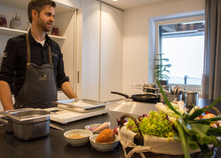 Koch steht in Küche vor Arbeitsfläche | © Land schafft Leben